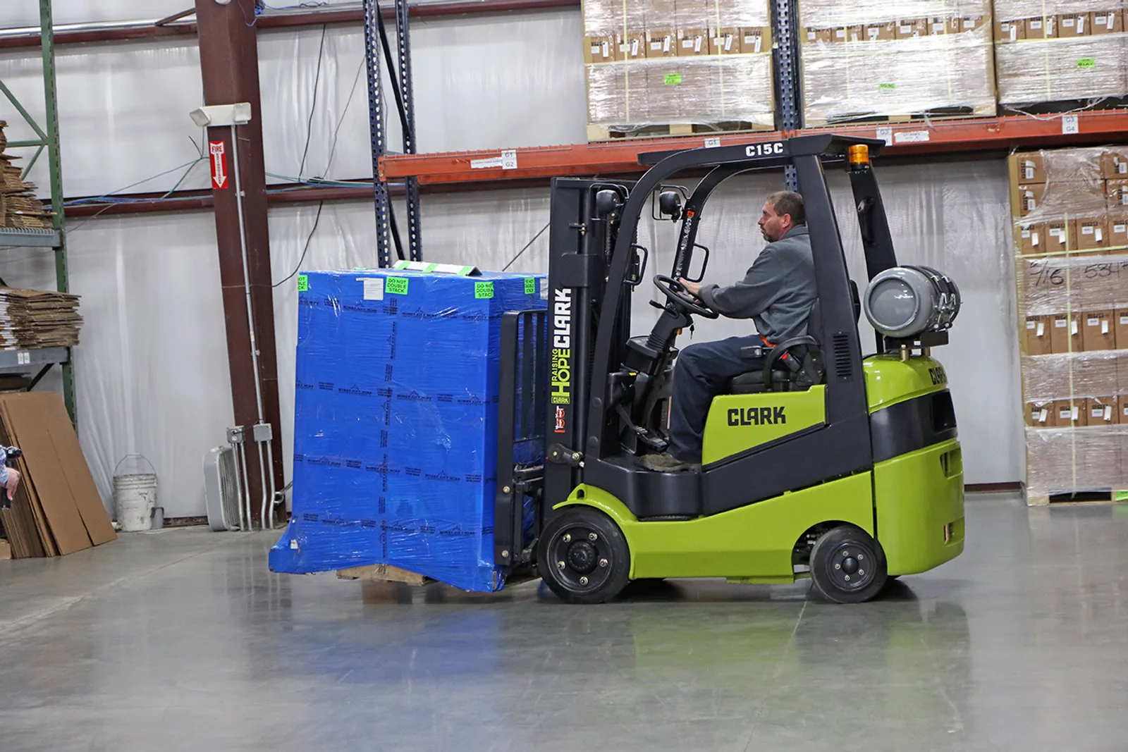Clark C15C forklift carrying a wrapped pallet past pallet racking in a Delaware warehouse