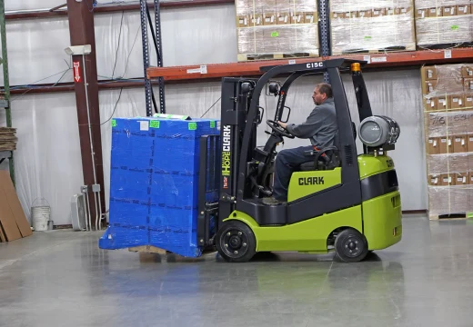 Clark C15C forklift carrying a wrapped pallet past pallet racking in a Delaware warehouse